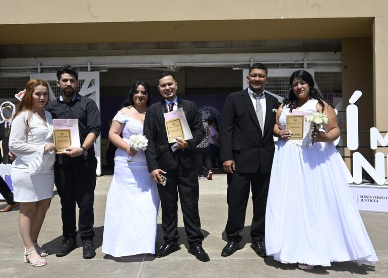 Felices parejas con su certificado o libreta de familia. 