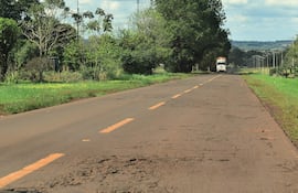 Camión en carretera rural con pavimento irregular y vegetación a los lados, en un entorno natural.