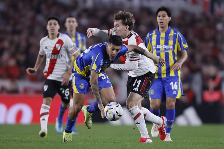 Facundo Colidio (d) de River disputa el balón con Emanuel Coronel de Rosario este sábado, en un partido de las semifinales de la Liga Argentina entre River Plate y Rosario Central en el estadio Monumental, en Buenos Aires (Argentina).
