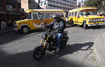 Un motociclista conduce en una calle bloqueada por conductores de transporte público, en La Paz (Bolivia).