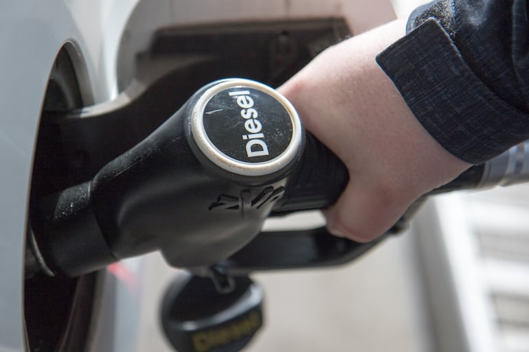 Una persona carga combustible en una estación de servicio.