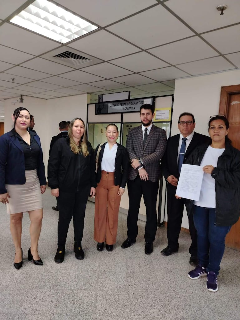 Grupo de seis personas en el juzgado: hombres con trajes y mujeres con abrigos, todos luciendo tranquilos y posando para la foto.