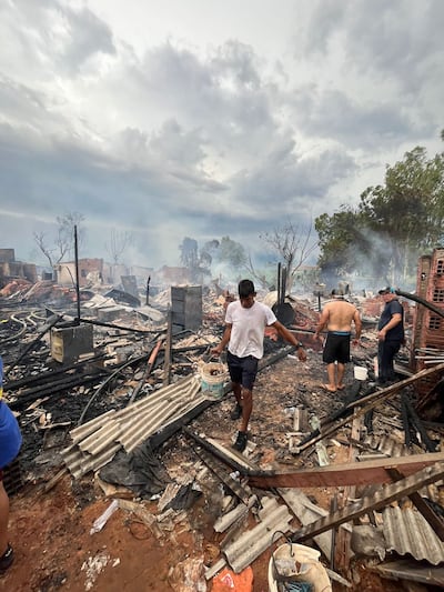 Lugareños llevan agua en balde para tratar de colaborar con los bomberos y exitnguir posibles focos de incendio.