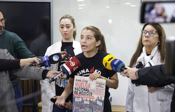 Rossana González con camiseta de 'SINA MED Paraguay' sostiene cartel de huelga, gesticulando mientras es observada por otras mujeres.