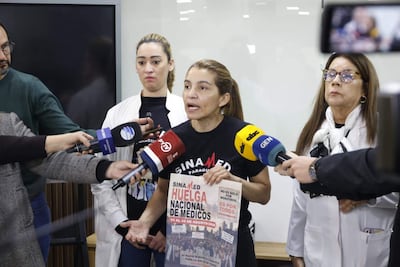Rossana González con camiseta de 'SINA MED Paraguay' sostiene cartel de huelga, gesticulando mientras es observada por otras mujeres.