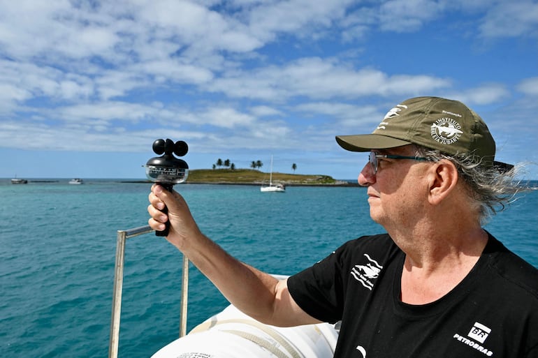 Milton Marcondes, investigador del Instituto de la Ballena Jorobada, utiliza un equipo para medir la velocidad y la dirección del viento en el archipiélago de Abrolhos, estado de Bahía, Brasil, el 18 de agosto de 2026.