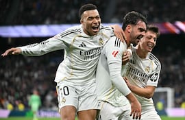 El defensa español del Real Madrid, Raúl Asencio, celebra con el delantero francés del Real Madrid, Kylian Mbappé, y el centrocampista turco del Real Madrid, Arda Güler, tras anotar el segundo gol de su equipo durante el partido de fútbol de la liga española entre el Real Madrid CF y el Levante UD en el Estadio Santiago Bernabéu.