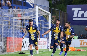 En el piso el arquero liberteño Morínigo, detrás del festejo de los trinidenses, que lo encabeza Gustavo Viera, el autor tras el rebote del penal, y participan Alan Cano, el debutante, y Ronaldo Báez,