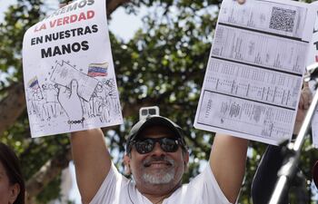 Un ciudadano venezolano sostiene un cartel en una concentración para manifestarse en contra de los resultados oficiales de las elecciones en Venezuela. La coalición opositora mayoritaria de Venezuela, la Plataforma Unitaria Democrática (PUD), denunció este sábado que funcionarios de la Guardia Nacional Bolivariana (GNB, policía militarizada) reprimieron a ciudadanos que salieron a la concentración convocada por el antichavismo en Maracay, estado Aragua.