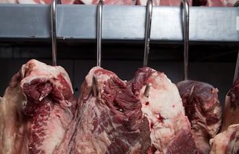 Cortes de carne colgados en ganchos.