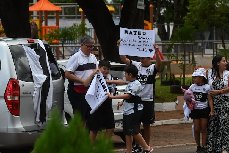 Hinchas de Olimpia con un cartel que nombra a Mateo Gamarra en las afueras del hotel de concentración en Pedro Juan Caballero en la previa del partido ante 2 de Mayo por la segunda fecha del torneo Apertura 2026 de la Primera División de Paraguay.