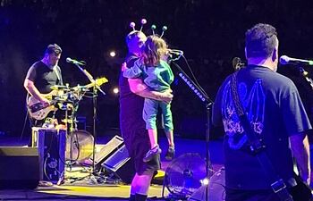 Randy Ebright, baterista de Molotov, con su hijo Elio en brazos en el escenario del anfiteatro José Asunción Flores.