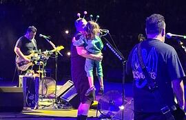 Randy Ebright, baterista de Molotov, con su hijo Elio en brazos en el escenario del anfiteatro José Asunción Flores.