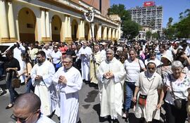 El cardenal Adalberto Martínez porta una cruz, en medio de la última peregrinación del año, en el microcentro de Asunción.