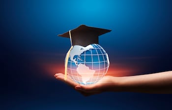 E-education concept. Hand outstreching globe hologram with graduation hat over blue background, collage