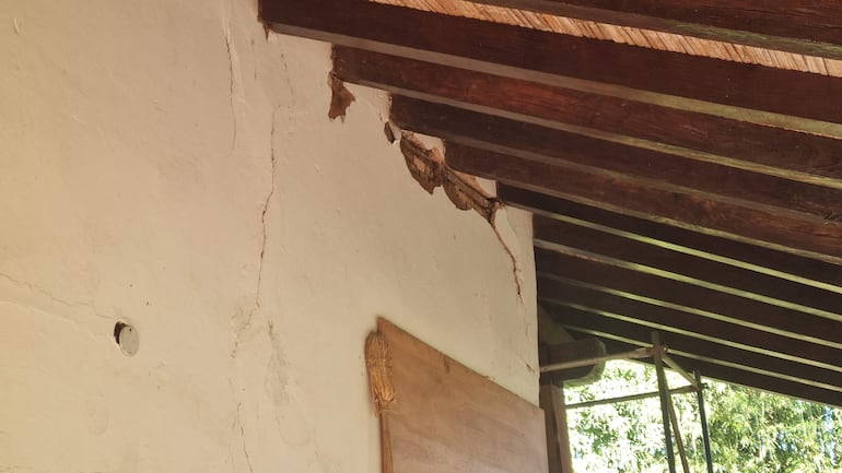 Grieta visible en la pared del Museo Jesuítico, con techo de madera y vigas expuestas, iluminado por luz natural.