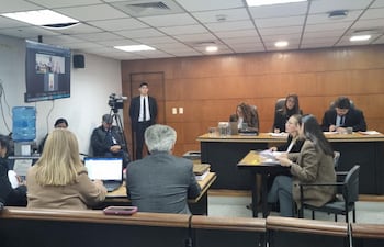 El brasileño condenado en su país, Marcus Vinicius Espindola, declara por vía telemática en el marco del juicio a Arnaldo Giuzzio. Frente al Tribunal de Sentencia, están sentadas la intérprete y la fiscala Verónica Valdéz.