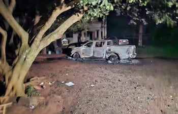 Vehículo dañado, ennegrecido por el fuego, en una zona urbana sin personas visibles.