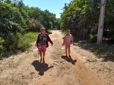 Pobladoras del asentamiento Atinguy caminan cerca de dos kilómetros para conseguir un poco agua del pozo de un vecino.
