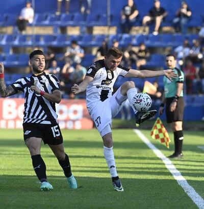 Héctor Villalba, de Libertad, pelea el balón con Walter Clar, jugador de Tacuary.