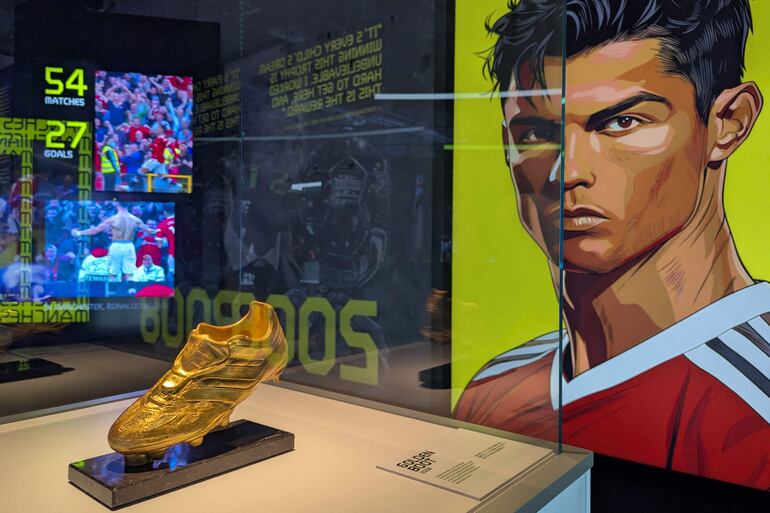 El trofeo Bota de Oro de Cristiano Ronaldo se exhibe junto a un retrato del futbolista durante la inauguración del Museo CR7 LIFE en Hong Kong.