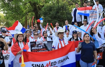 AME2765. CAMBYRETÁ (PARAGUAY), 28/08/2026.- Un grupo de médicos participa en una manifestación en la que exigen un reajuste de salarios, dotación en los hospitales y mejores condiciones laborales este viernes, en Cambyretá (Paraguay). Los médicos, quienes están en huelga desde el pasado lunes, salieron a las calles del departamento paraguayo de Itapúa que es escenario del Campeonato Mundial de la especialidad (WRC) por segundo año consecutivo. EFE/ Cristian Bartomeus