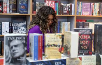 Una persona observa libros es un stand de la Feria Internacional del Libro de Quito. Los libros y las películas del futuro podrían empezar a parecerse entre sí si las industrias creativas se entregan a la inteligencia artificial (IA) para ayudarse a escribir historias, advirtió un estudio publicado el viernes.