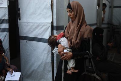 Una mujer sostiene a su hija de ocho meses, con desnutrición severa, en un punto de atención médica en la Ciudad de Gaza, el pasado 11 de julio.