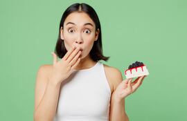 Efectos del azúcar en el cerebro. Mujer con un postre en la mano.