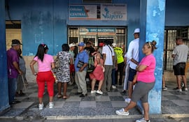 Cuabos esperan frente a caseta de buses en La Habana. (archivo)