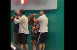 Captura de video del momento en el que una pareja interviene para evitar que Nenecho y un hombre lleguen a los golpes.