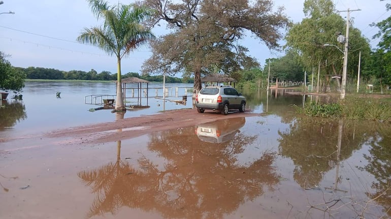 SUV gris estacionado en terreno húmedo, rodeado de agua y vegetación, sin personas visibles en la escena.