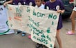 Niños con camisetas moradas sostienen un gran cartel que dice 'Yo 177', al aire libre en un ambiente urbano.