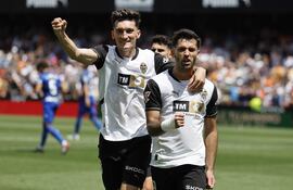 El delantero del Valencia Hugo Duro (d) celebra con su compañero Pepelu tras marcar el 3-0 al Getafe durante el partido de LaLiga EA Sports disputado este sábado en el Estadio de Mestalla en Valencia. EFE/Ana Escobar