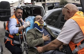 Socorristas palestinos trasladan a una ambulancia al fotógrafo de la AFP Jaafar Ashtiyeh tras ser golpeado por unos israelíes el 6 de octubre de 2026 en Aqraba, en la Cisjordania ocupada por Israel (Foto: John Wessels)