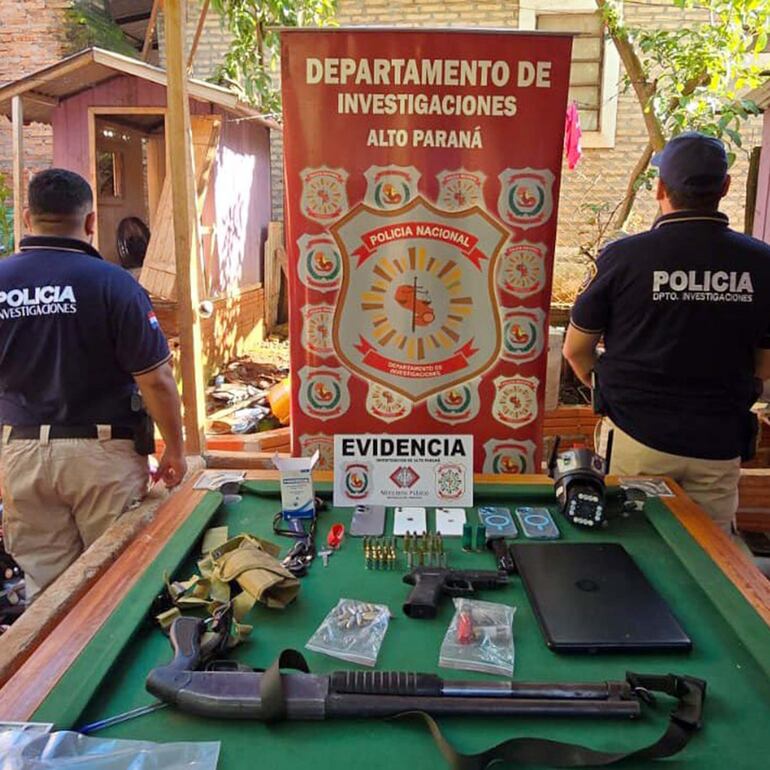 Agentes de Investigaciones con la escopeta y pistola halladas en Presidente Franco.