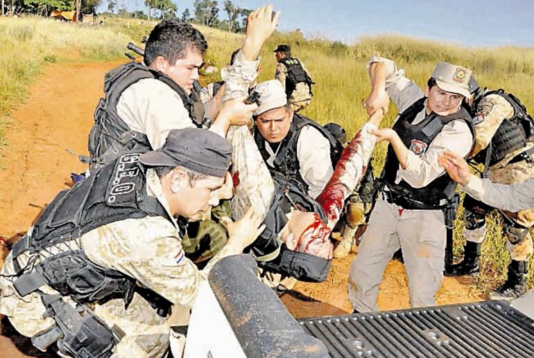 Policías cargan a uno de sus camaradas que fue herido durante la masacre de Curuguaty, el 15 de junio de 2012.