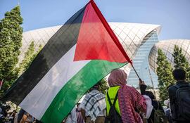 Una persona con una bandera palestina durante una protesta contra los ataques israelíes contra Palestina y el Líbano, ayer lunes en Kuala Lumpur, Malasia.