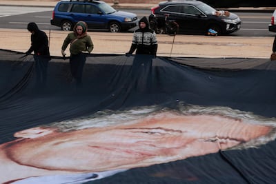 Un cartel gigante que muestra a Jeffrey Epstein y al presidente estadounidense Donald Trump es desplegado cerca del Capitolio de Washington, ayer lunes.