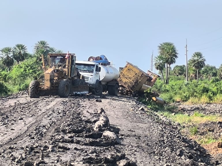 Un tractor ayuda a un camión cisterna a pasar por el camino que conduce a la bioceánica.