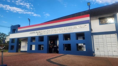 Fachada de la Junta de Bomberos, edificio azul con franjas blancas y rojas, cielo despejado.