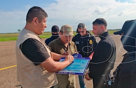 Sebastián Marset (con buzo negro y esposado) antes de subir al avión que lo trasladará a su próximo destino.