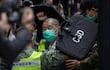 Jimmy Lai (C), director periodístico y activista prodemocracia de Hong Kong, es escoltado por la policía.
