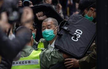 Jimmy Lai (C), director periodístico y activista prodemocracia de Hong Kong, es escoltado por la policía.