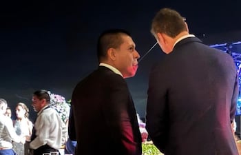 Miguel Vázquez habla al oído al presidente Santiago Peña.