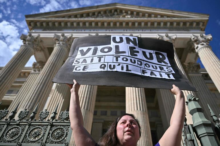 Una mujer sostiene una pancarta que dice "Un violador siempre sabe lo que hace" frente al juzgado de Nimes, en el sur de Francia, durante el juicio de apelación en el caso de violación de Mazan.