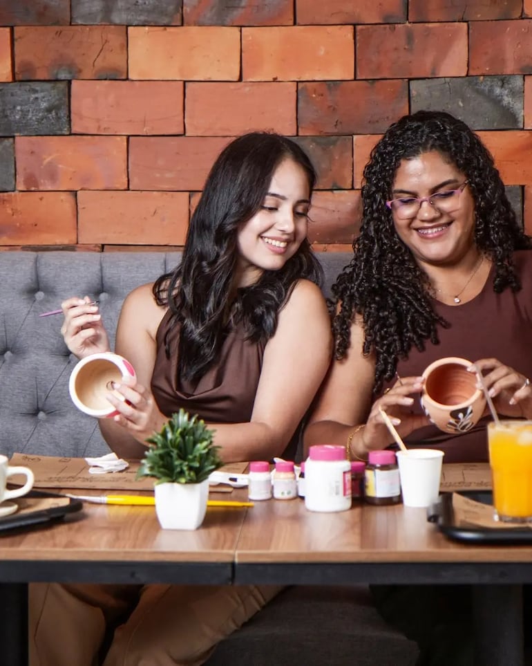 Las jóvenes disfrutan de pintar cerámica y encuentran en esta actividad una forma creativa de relajación y entretenimiento.