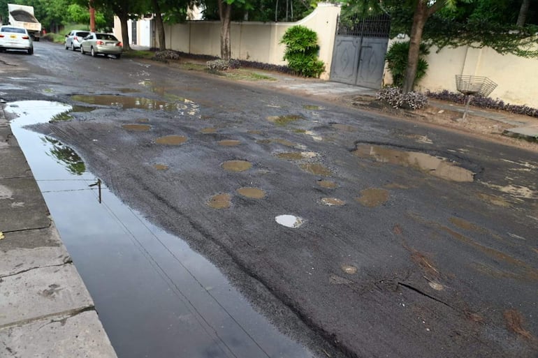 Trabajadores de la Dirección de Vialidad de la Municipalidad de Asunción realizan tareas de pavimentación en Calle Pizarro, barrio Santa Librada, Asunción. Los trabajos se realizaron mientras la pista estaba llena de agua.