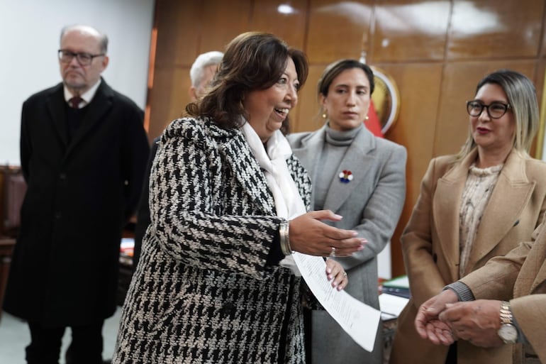 Mirtha Arias gesticula con documentos mientras Mónica Recalde escucha en ambiente de oficina.