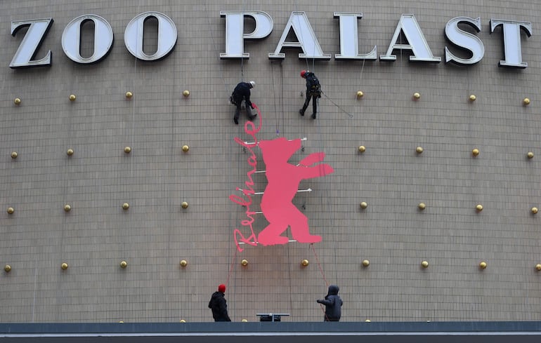 Obreros trabajando en la fachada del Zoo Palast antes de la inauguración de la Berlinale